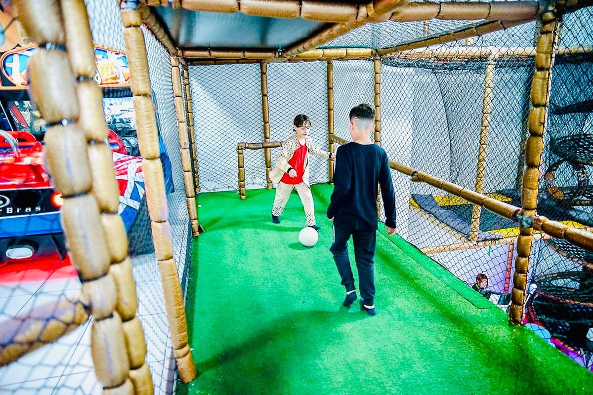 Meninos jogando bola no campinho society