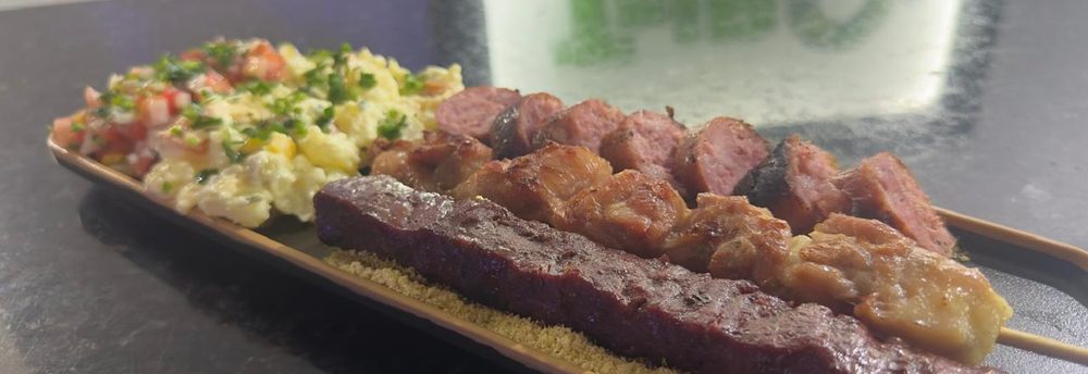 Prato de churrasco com espetinhos, maionese, farofa e vinagrete