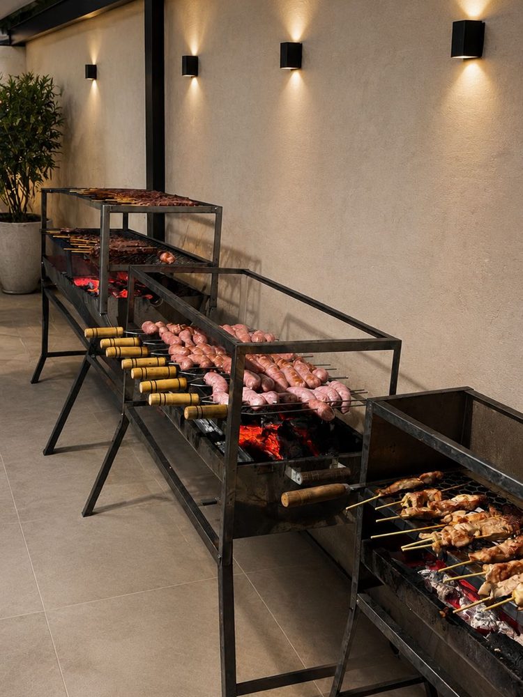 Churrasqueiras com espetinhos de carne, frango e linguica na brasa