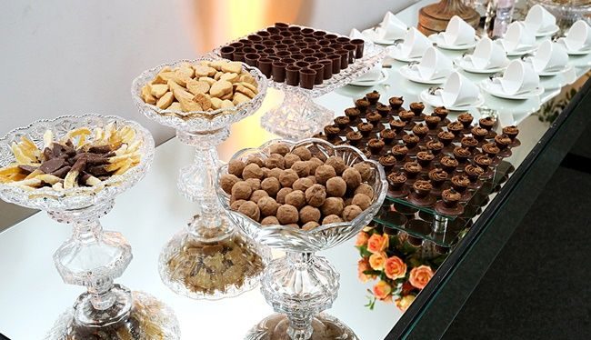 Mesa de encerramento com doces finos, bolachas e bombons em taças de cristal
