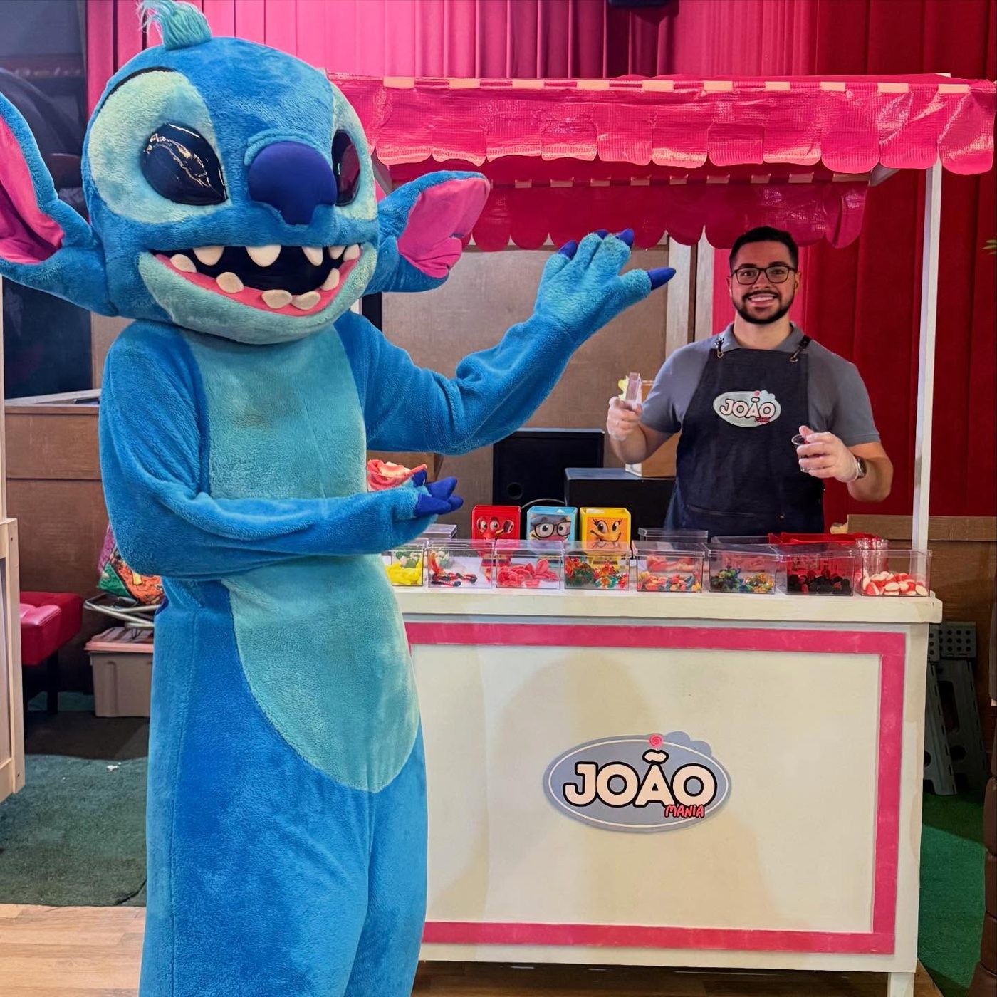 Personagem ao lado do carrinho de balas João Mania montado no salão